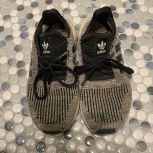 Very used black and gray adidas tennis shoes, loose threads. Size 4 1/2